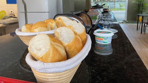 A breakfast buffet with bread and yogurt. - Pousada Pontal do Sul (Pontal do Parana)
