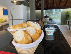 A breakfast buffet with bread and yogurt. - Pousada Pontal do Sul (Pontal do Parana)