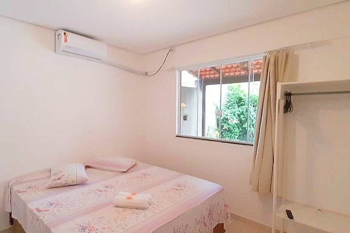 A bedroom with a bed, a window, and a door.