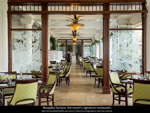 A restaurant with a long counter and green chairs, featuring a decorative ceiling and a view of the outdoors. - 4 Star Beach Front Hotel Resort, Lanai Ocean View, one minute walk to the beach (Lihue)