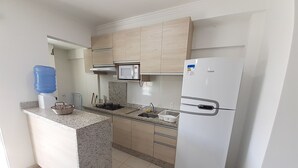 A modern kitchen with a built-in microwave, a refrigerator, a water dispenser, and a gas stove. - 318, Great Value 3-Bedroom Apartment (Bombas)