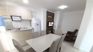 A modern kitchen with a dining area, white cabinets, a microwave, and a refrigerator. - 318, Great Value 3-Bedroom Apartment (Bombas)