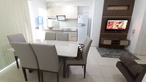 A modern living room with a dining area, a kitchen, and a TV. - 318, Great Value 3-Bedroom Apartment (Bombas)
