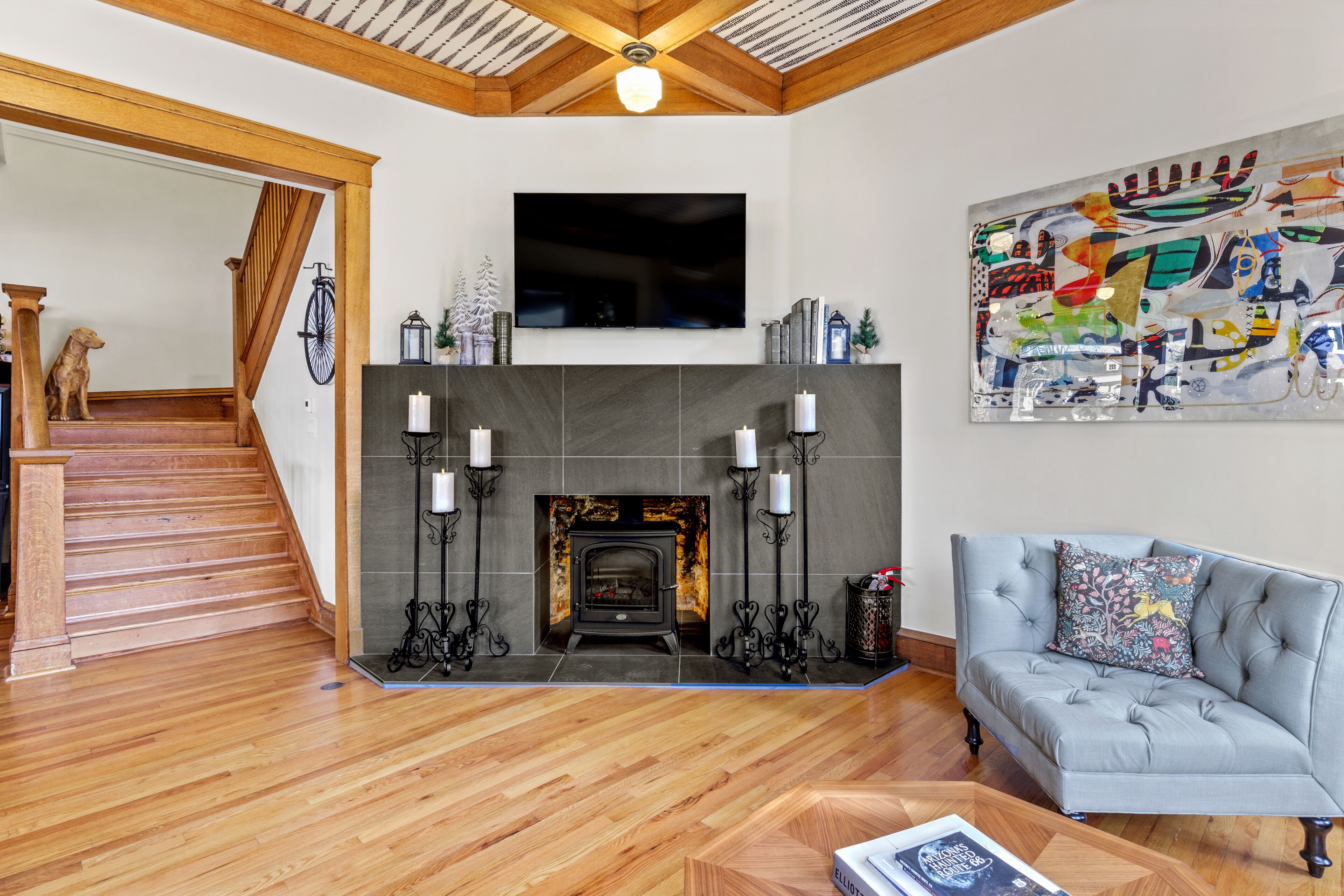Una sala de estar con chimenea, un sofá y un televisor montado en la pared.
