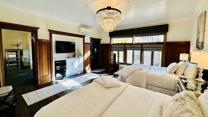Une chambre d’hôtel avec deux lits, un lustre, une télévision et une vue sur l’extérieur.