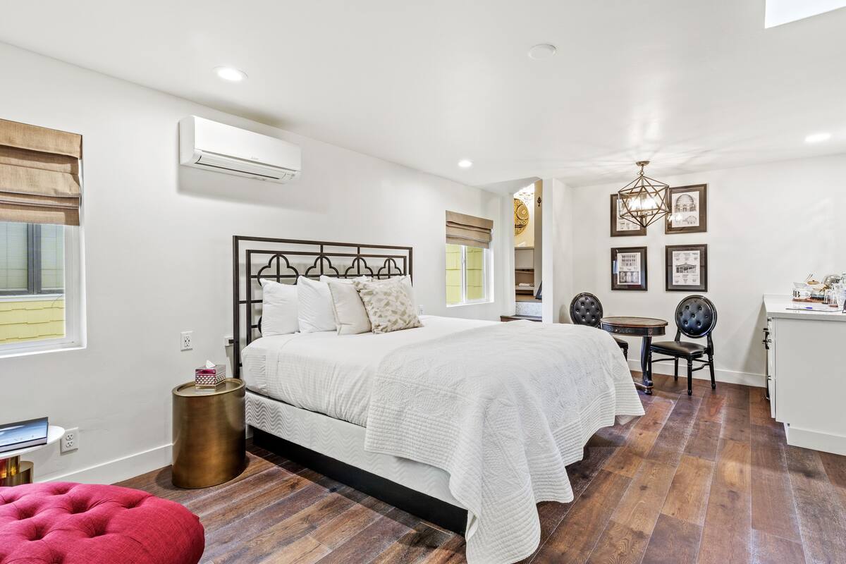 A bedroom with a large bed, bedside tables, a desk, and a chair.