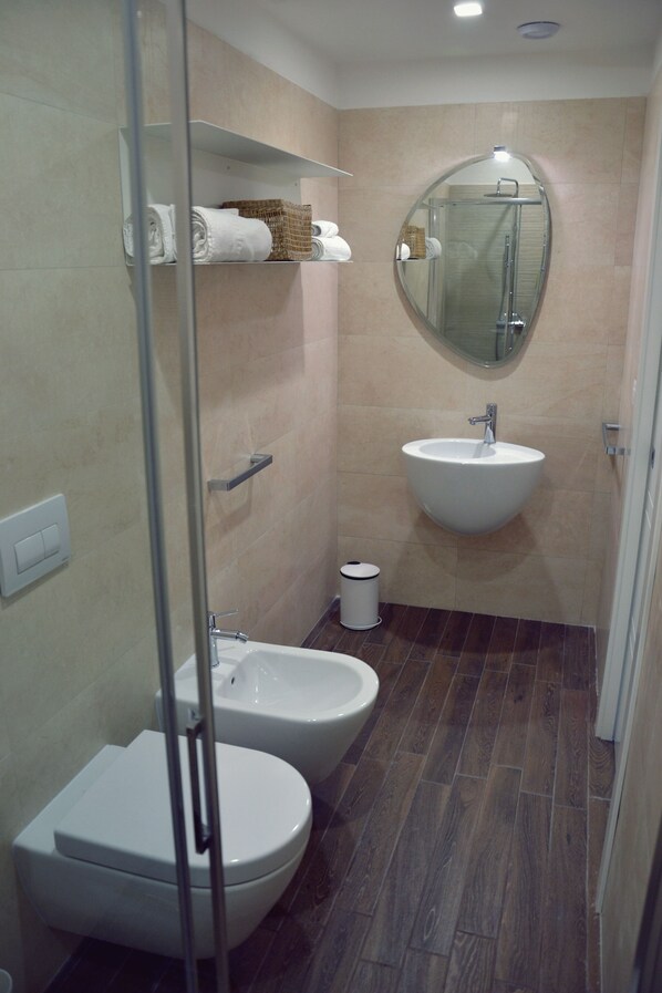 A modern bathroom with a bidet, a sink, and a toilet.