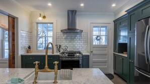A kitchen with a central island, a stove, and a refrigerator.