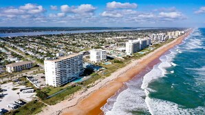 Eine Küstenstadt mit Strandhotels, einem Sandstrand und Meereswellen.