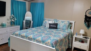 A bedroom with a bed, a dresser, a mirror, a nightstand, and a dreamcatcher. - 10 Acres  Farm House (Frostproof)