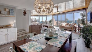 Amplia sala de estar con una gran mesa de comedor, asientos cómodos y vista al océano.