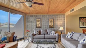 A spacious living room with a ceiling fan, two sofas, a coffee table, and a patterned rug. - Ocean-Pool Views From 2 Balconies | MP315 (Port Aransas)
