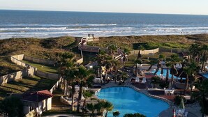 A resort with a swimming pool, beach access, and a view of the ocean.