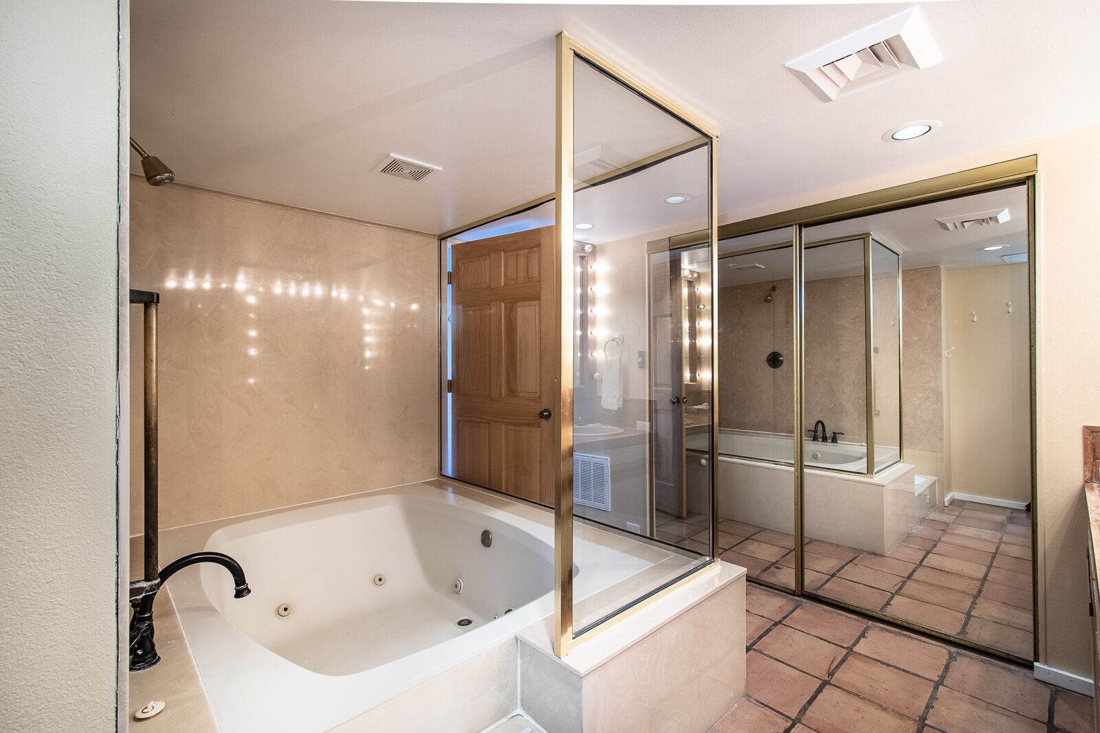 A modern bathroom with a freestanding bathtub, a glass-enclosed shower, and a large mirror.