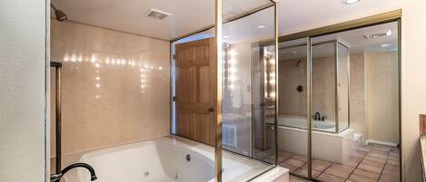A modern bathroom with a freestanding bathtub, a glass-enclosed shower, and a large mirror.