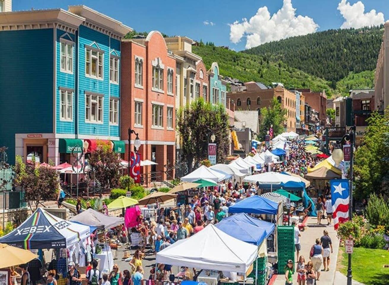 Un mercado al aire libre animado, con coloridas carpas y una multitud de gente.