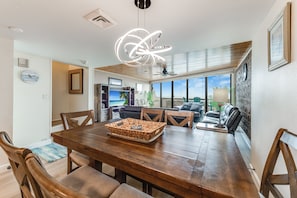 Enjoy meals in this dining area with a large table for four, surrounded by matching chairs and a woven basket.