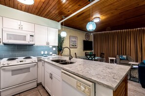 Enjoy casual dining and socializing in this well-organized kitchen and dining area, complete with a stove, microwave, and sink.