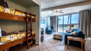 A room with bunk beds, a sofa, and a ceiling fan. - Sassy Seagull @ The Mayan Princess (Port Aransas)
