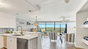 A spacious kitchen with a large island, white cabinetry, and a view to the outdoors. - Poolside views | Private access to beach | Beachfront | MP103 (Port Aransas)
