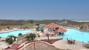 A swimming pool with a wooden deck, lounge chairs, and a gazebo.