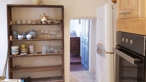 A kitchen with a wooden cabinet, a white refrigerator, and a built-in oven.
