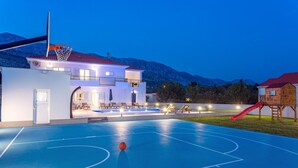A basketball court with a pool, lounge chairs, and a wooden playhouse with a slide. - VILLA ALMIC with heated pool, 5 bedrooms, Media room,multi-use playground court (Naklice)