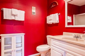 A bathroom with red walls, white fixtures, and a vanity with a sink and mirror. - Summit #257 Bldg. B (Mammoth Lakes)