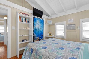 A bedroom with a bed, a bookshelf, a television, and a window with blinds. - 5 minutes to Dolphin Research Center
Family and Pet-Friendly! (Marathon)