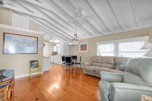 A spacious living area with a wooden floor, a dining table with chairs, a sofa, and a ceiling fan. - 5 minutes to Dolphin Research Center
Family and Pet-Friendly! (Marathon)
