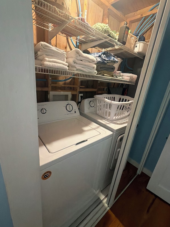 A laundry room with stacked towels, a washing machine, and a dryer.
