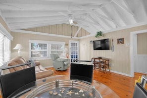 A living room with a glass coffee table, a sofa, a television, and a ceiling fan. - 5 minutes to Dolphin Research Center
Family and Pet-Friendly! (Marathon)
