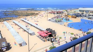A beach with umbrellas, a playground, and a pool. - Blue Beach Apartment (Póvoa de Varzim)