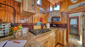 Una cocina con armarios de madera, encimera de granito, estufa y un cartel que indica que es una habitación para no fumadores.