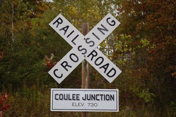 Señal de cruce de ferrocarril con la leyenda 'COULEE JUNCTION' y la altitud '730' debajo.