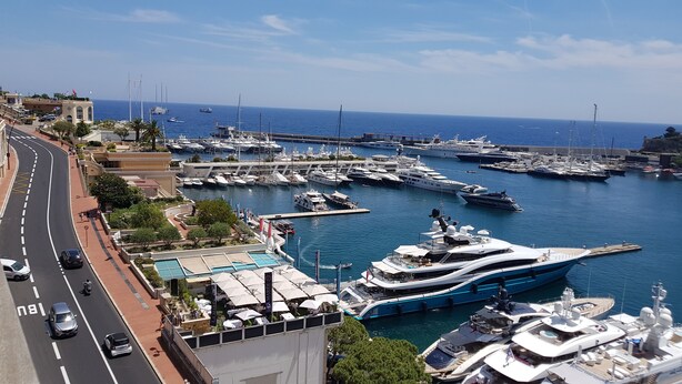 A marina with multiple yachts docked, a road with vehicles, and a clear view of the sea. - 2 ROOMS GREAT TERRACE ROOFTOP FULL CITY CENTER (Nice)