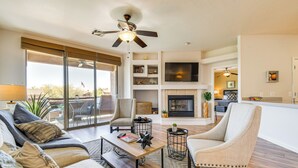 A spacious living room with a sofa, armchair, coffee table, and a fireplace.