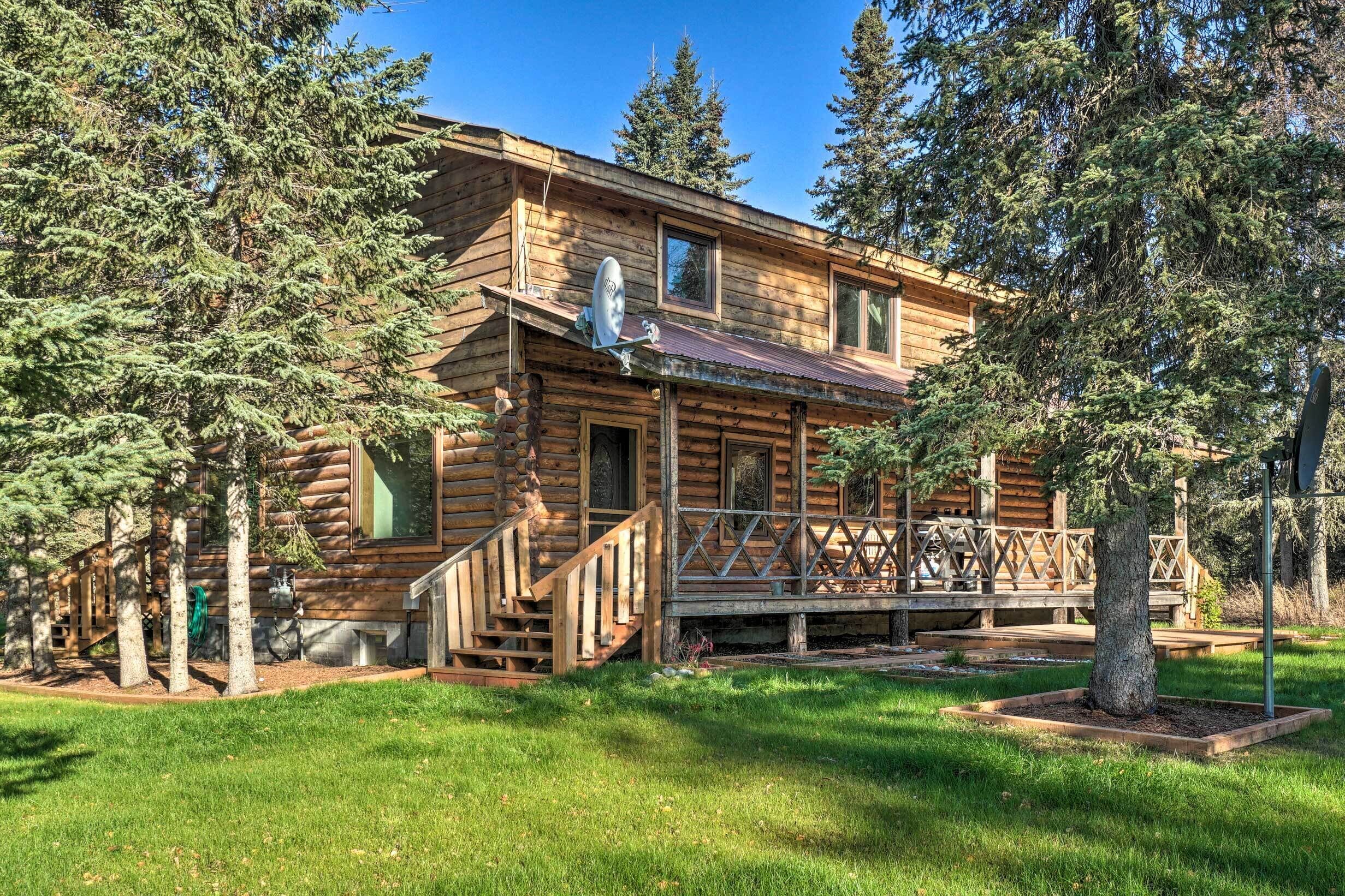 A log cabin with a porch, stairs, and a satellite dish.