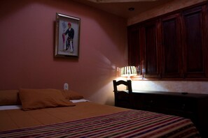 A bedroom with a bed, a chair, a desk, and a cabinet. - Casa San Miguel Arcangel (Antigua Guatemala)
