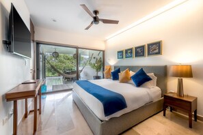 Ein modernes Schlafzimmer mit einem großen Bett, einem Deckenventilator, einem Fernseher und einem Balkon mit einer Hängematte.