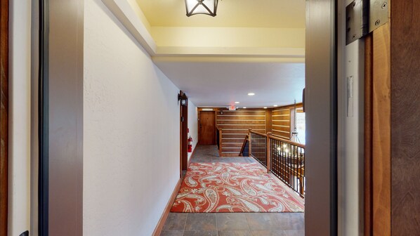 Staircase leads to an upper level with a handrail and wooden steps.