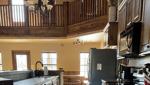 A spacious kitchen with dark wooden cabinets, a large island, and a built-in oven.