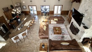 A spacious living area with a kitchen, bar, and seating arrangements.