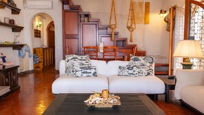 A cozy living room with a sofa set, a coffee table with decorative items, wooden furniture, and a staircase leading to an upper level. - Cozy home in Tarquinia (VT) with WiFi (Tarquinia (VT))