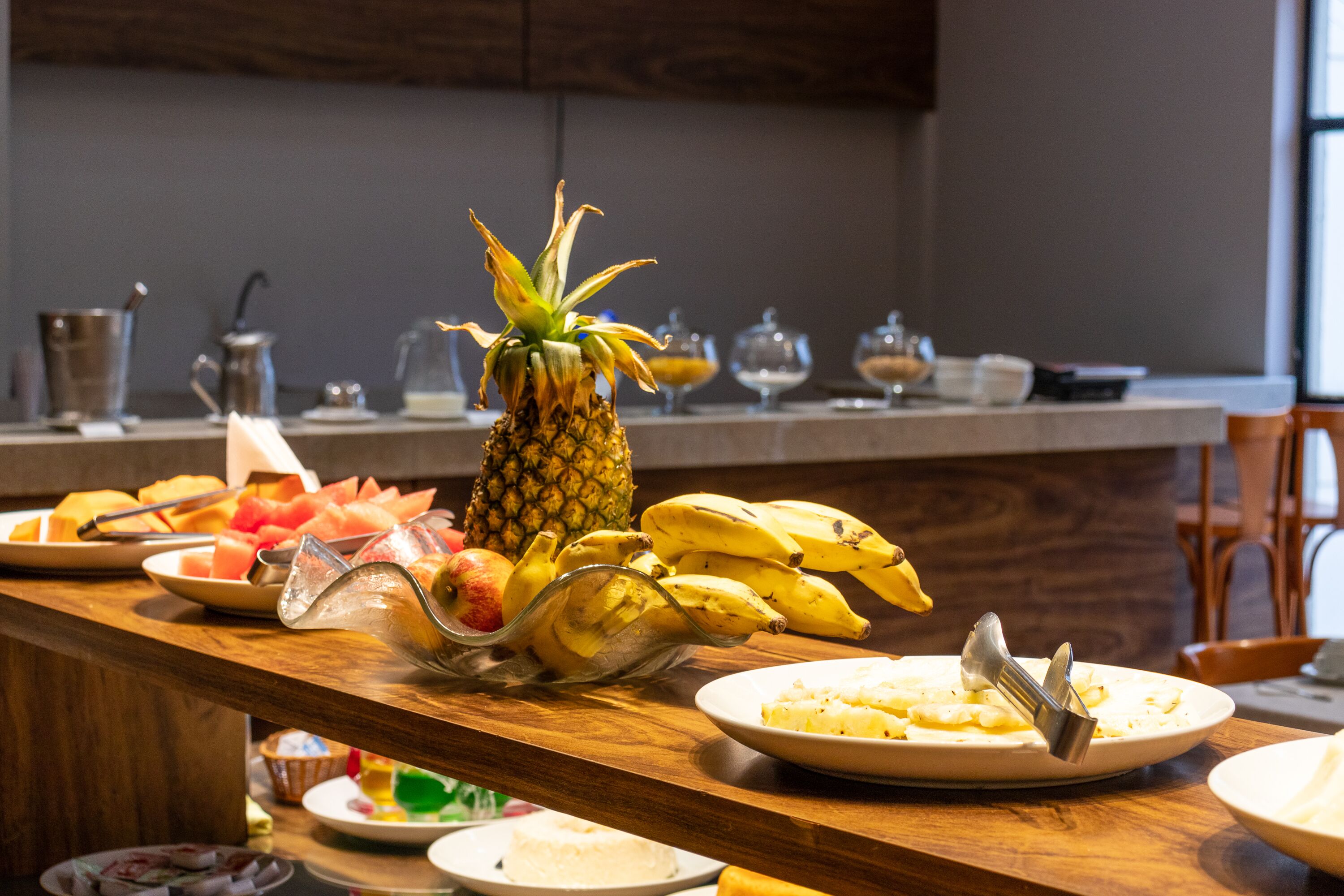 Un bufé de desayuno con diversas frutas y platos.
