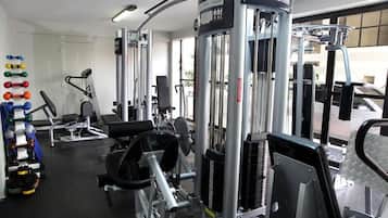 A gym with various exercise equipment, including weight machines and free weights.