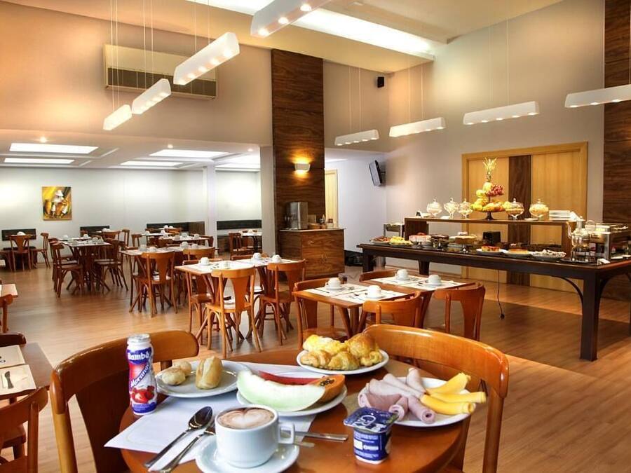 Un comedor de hotel con varias mesas, sillas y una mesa de buffet.
