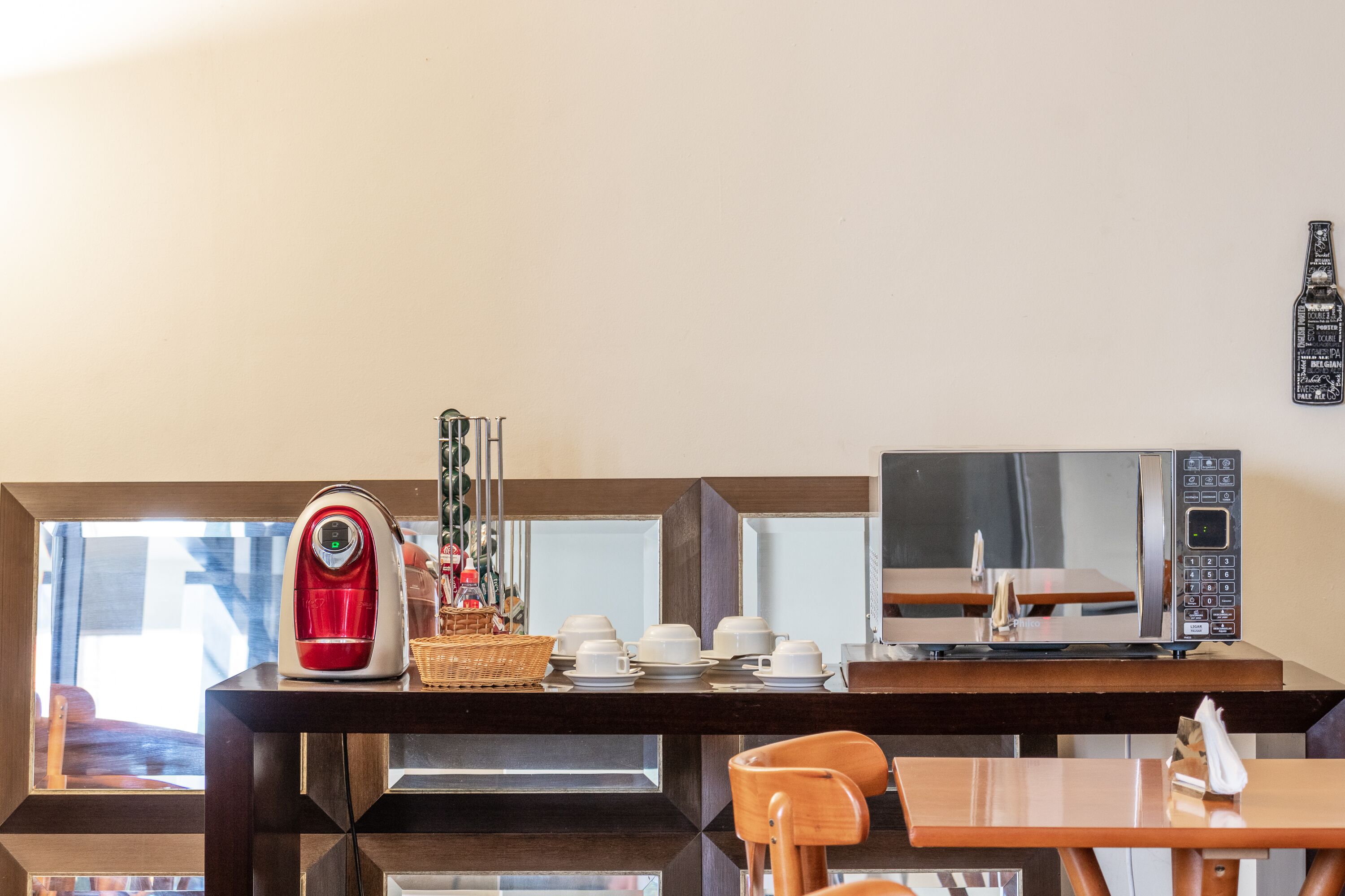 Un desayunador con cafetera, microondas y mesa de comedor con sillas.