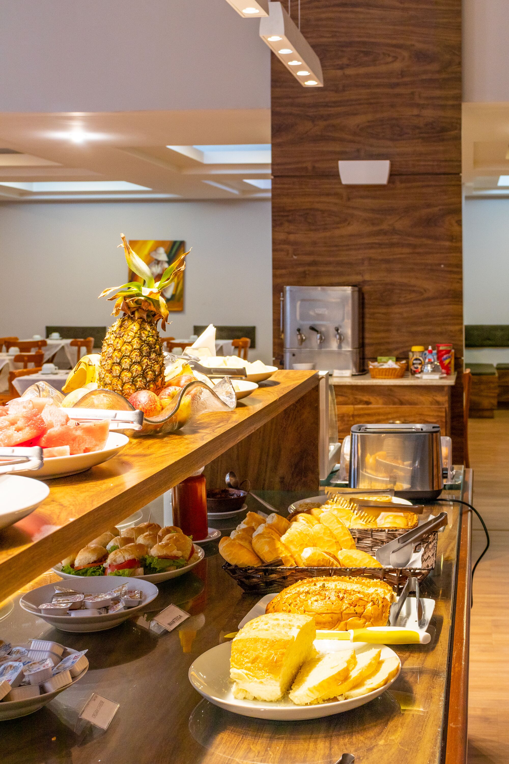 A buffet with various food items including bread, fruits, and sandwiches.