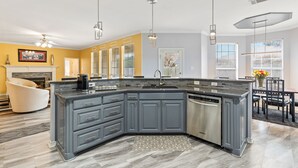 Une cuisine moderne avec des meubles de couleur grise, un lave-vaisselle encastré et un grand îlot central.